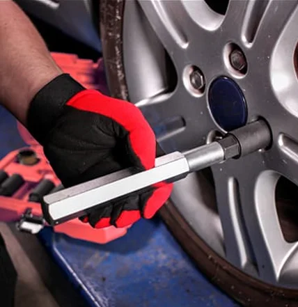 Mechanic from Coastal Tyre Services using a torque wrench on a car wheel.