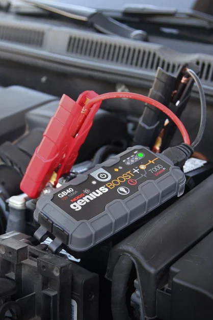 Coastal Tyre Services' portable car battery booster connected to a vehicle's battery.